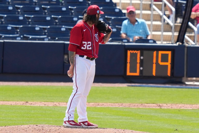 Washington Nationals starting pitcher Trevor Williams (32) prepares to throw as the pitch clock runs during a spring training baseball game against the Miami Marlins, Saturday, March 18, 2023, in West Palm Beach, Fla. 