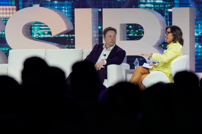 Twitter CEO Elon Musk, center, speaks with Linda Yaccarino, chairman of global advertising and partnerships for NBC, at the POSSIBLE marketing conference, Tuesday, April 18, 2023, in Miami Beach, Fla. 