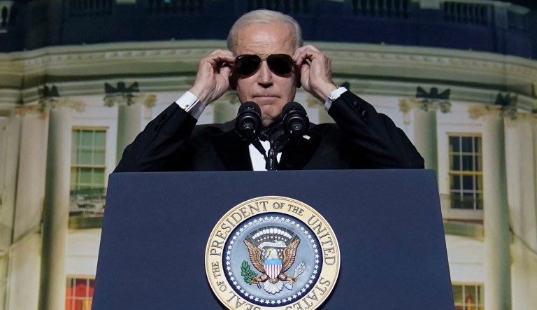 President Joe Biden puts on sunglasses as he makes a joke about becoming the 