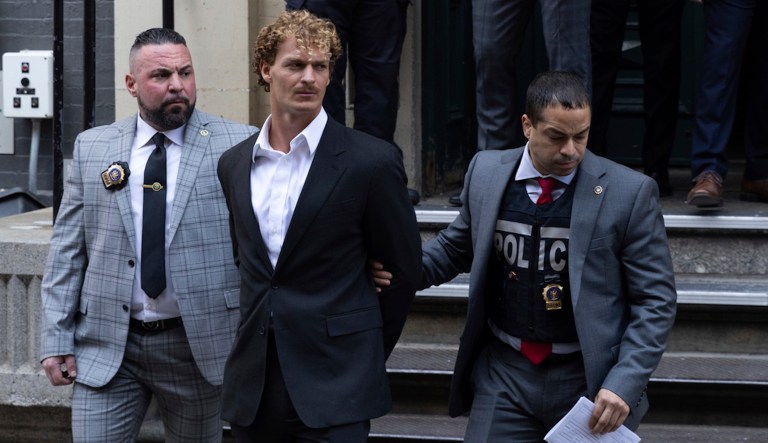 Daniel Penny, center, is walked by New York Police Department detectives out of the 5th Precinct on Friday, May 12, 2023, in New York. 