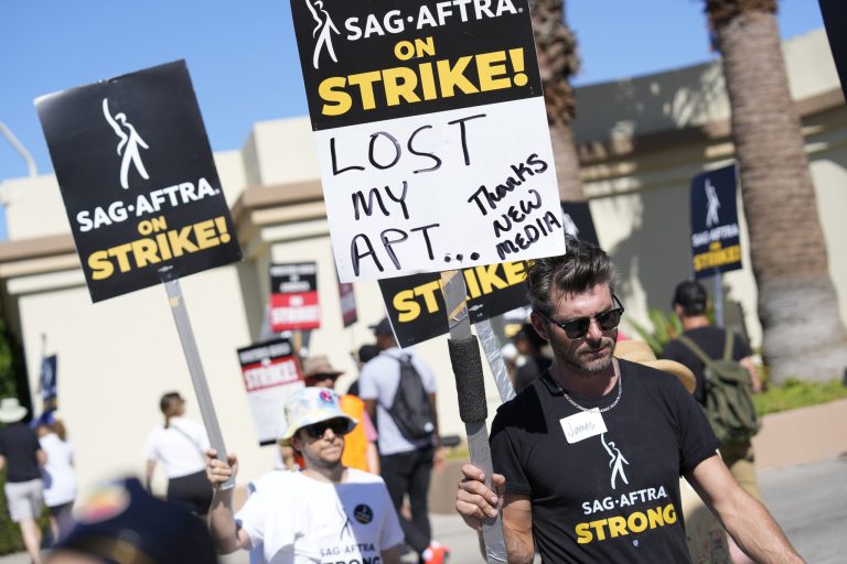 SAG-AFTRA member James Hutson carries a picket sign outside Paramount studios on Wednesday, July 19, 2023, in Los Angeles. The actors strike came more than two months after screenwriters began striking in their bid to get better pay and working conditions. 