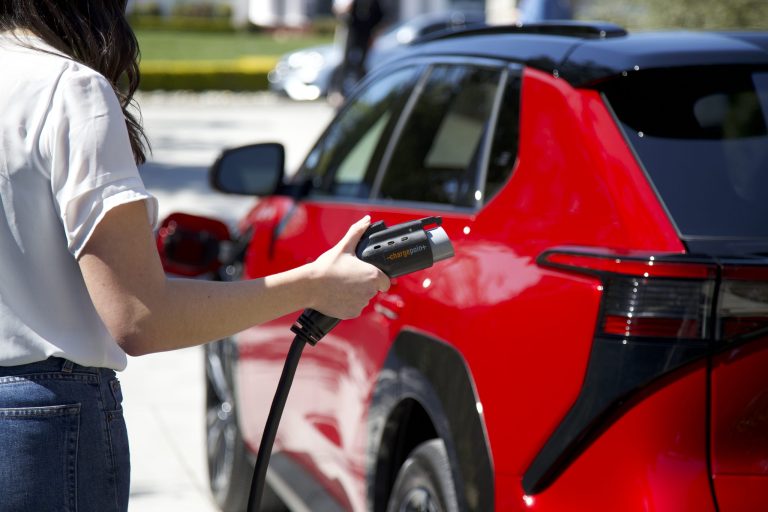 A user of Toyotaâs new battery electric bZ4X crossover charges the vehicle.