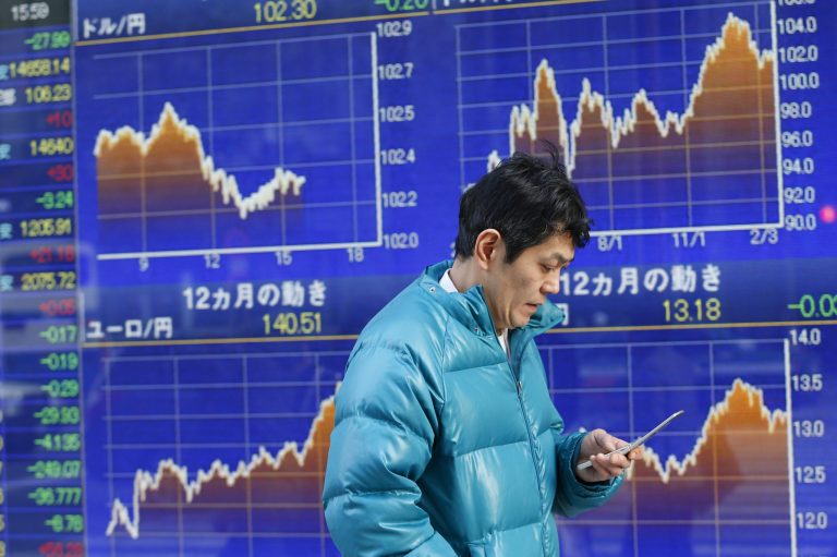 A man uses a mobile phone in front of a securities firm's electronic stock board in Tokyo, Monday, Feb. 24, 2014. Asian stock markets mostly fell Monday after a slower increase in Chinese property prices added to jitters about the strength of the world's No. 2 economy. Japan's Nikkei 225 stock average was down 0.19 percent at 14,837.68. (AP Photo/Shizuo Kambayashi)