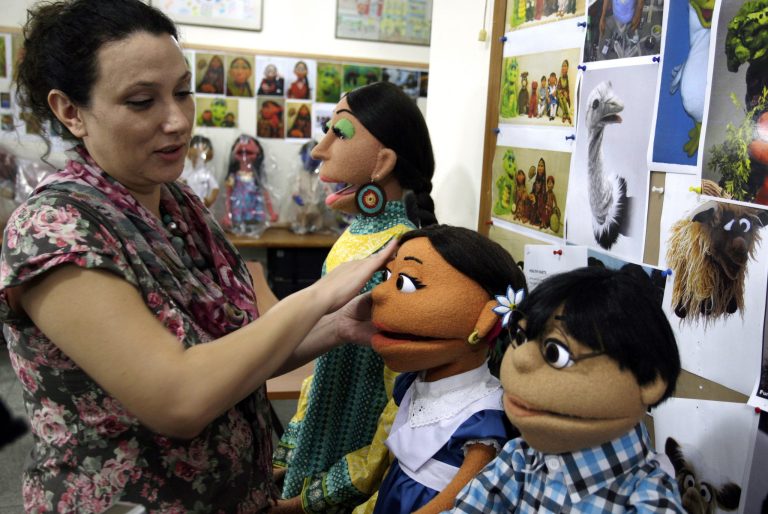   FILE - In a Oct. 13, 2011 file photo, a Pakistani artist, left, gives final touches to characters of Pakistani Sesame Street in Lahore, Pakistan. The U.S. Embassy in Pakistan says it terminated funding for a $20 million project to develop a local version of Sesame Street amid reports of corruption. Embassy spokesman Robert Raines said Tuesday, June 5, 2012, the U.S. terminated funding but declined to provide details. (AP Photo/K.M.Chaudary, file)  