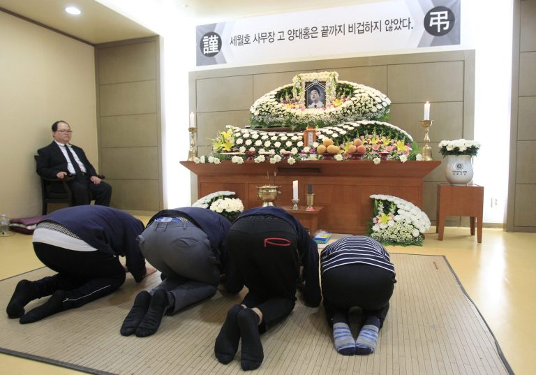 In this May 16, 2014, HOLD FOR USE WITH STORY SLUGGED SOUTH KOREA SHIP SINKS DEMONIZED CREW BY YOUKYUNG LEE, middle school students bow during a memorial service for South Korean ferry Sewol chief officer Yang Dae-hong at a hospital in Incheon, South Korea. The letters at a banner read Sewol ferry chief officer Yang Dae-hong was not a coward to the end