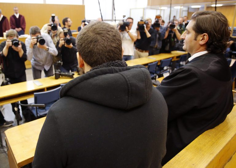 German Kreshnik B. , left, waits for the beginning of his trial at a higher regional court in Frankfurt,  Germany, Monday, Sept.15, 2014. He is accused of having been a member of the Islamic state group in Syria. He was arrested when he came back to Germany in December 2013. (AP Photo/Michael Probst)