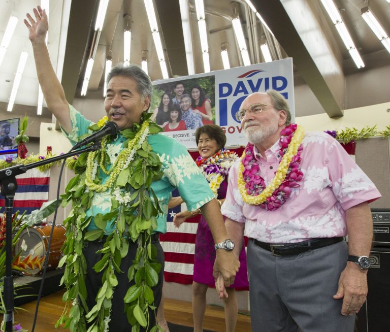 Hawaii State Sen. David Ige, left, waves to his supporters and thanks Hawaii Governor Neil Abercrombie, right, who promised his support Saturday, Aug. 9, 2014, in Honolulu. (AP Photo/Eugene Tanner)