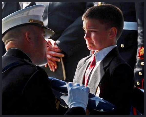 Photo: Boy receives flag from father’s casket
