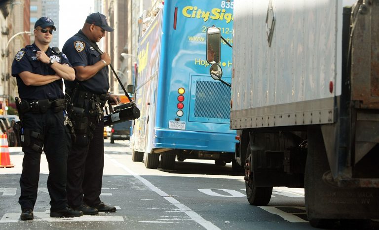 New York Police Department officers use a radiation detection device to monitor traffic following a 'dirty bomb' threat Aug. 11, 2007 in New York City. New rules in counter-terrorism operations would ban profiling based on religion, ethnicity or sexual orientation and includes no exemption for national security investigations. (Photo by Mario Tama/Getty images)