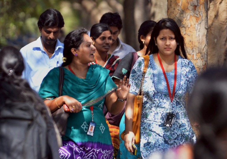 In this Wednesday, March 26, 2014 photo, young Indian employees of Infosys Technologies walk outside the company's headquarters at Electronic City in Bangalore, India. As the world's largest democracy of 1.2 billion people, including 814 million voters, launches a marathon six-week national election contest, all eyes are on India's enormous population of ambitious, tech-savvy and politically engaged youths. Nowhere is the high-tech transition more clear than amid the bright cafes and technology companies of Bangalore, seen as the economy's beating heart and brain trust with its large number of scientists, engineers and corporate professionals drawn from India's brightest youths. With 63 percent of its population under 25, Bangalore is one of India's youngest cities. (AP Photo/Kashif Masood)