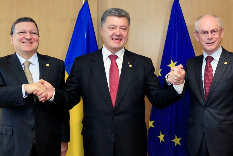 Ukraine's President Petro Poroshenko, center, poses with European Commission President Jose Manuel Barroso, left, and European Council President Herman Van Rompuy, right, during an EU Summit in Brussels on Friday, June 27, 2014. Ukrainian President Petro Poroshenko has signed up to a trade and economic pact with the European Union, saying it may be the 