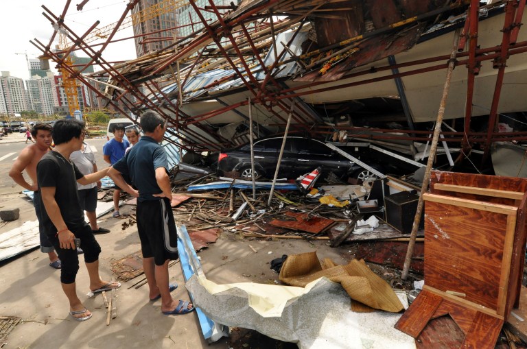 In this Saturday, July 19, 2014 photo released by China's Xinhua News Agency, a vehicle sits under a collapsed building after landfall of typhoon Rammasun in Haikou, capital of south China's Hainan Province. The strongest typhoon to hit southern China in four decades has killed more than a dozen people, the government said Sunday. (AP Photo/Xinhua, Xia Yifang) NO SALES