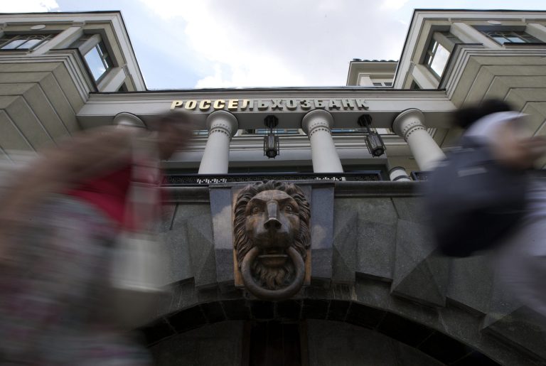 People walk past the headquarters of Russian Agricultural Bank in downtown Moscow, Russia, on Wednesday, July 30, 2014. The European Union approved dramatically tougher economic sanctions Tuesday, July 29, against Russia, followed swiftly by a new round of U.S. penalties. Among the targets were three Russian banks: the Bank of Moscow, Russian Agricultural Bank and VTB Bank, Russia's second largest bank. (AP Photo/Ivan Sekretarev)