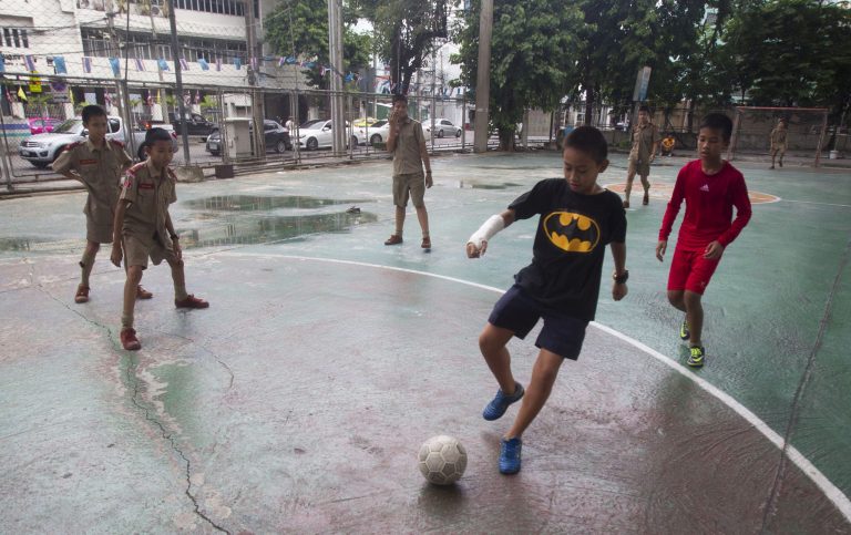 Thai students play soccer under expressway in Bangkok, Thailand, Thursday, June 12, 2014. On Thursday, the National Broadcasting and Telecoms Commission announced it had struck a 427 million baht ($13 million) compensation deal with RS so the entire World Cup can be shown on free channels.(AP Photo/Sakchai Lalit)