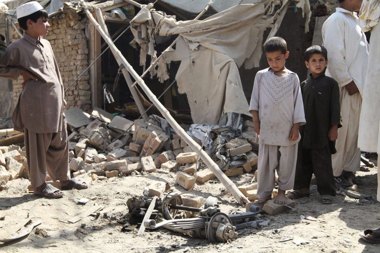 Afghan children stand near the wreckage of a vehicle after an explosion in Kandahar, south of Kabul, Afghanistan, Monday, July 9, 2012. (AP Photo/Allauddin Khan)