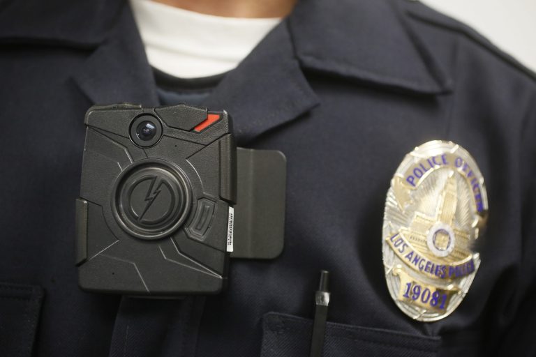FILE - In this Jan. 15, 2014 file photo, a Los Angeles Police officer wears an on-body camera during a demonstration for media in Los Angeles. The fatal police shooting of the unarmed black teenager in Ferguson, Mo. has prompted calls for more officers to wear so-called 