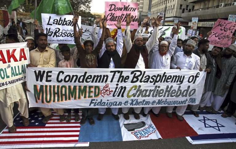 Supporters of a Pakistani religious group 'Fidaiyan-e-Khetm-e-Nebuwwat' stand on the representations of American, French and Israeli flags and chant slogans during a demonstration to protest against caricatures published in French magazine Charlie Hebdo, in Karachi, Pakistan, Saturday, Jan. 17, 2015. (AP Photo)