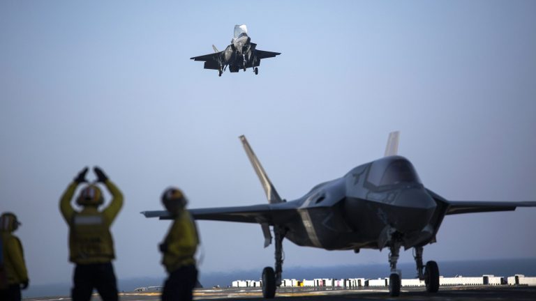 A sailor aboard the USS Wasp Â signals to the pilot of an F-35B Lightning II Joint Strike Fighter to land as it arrives for the first phase of operational testing, May 18, 2015.Â (U.S. Marine Corps photo/Lance Cpl. Remington Hall)