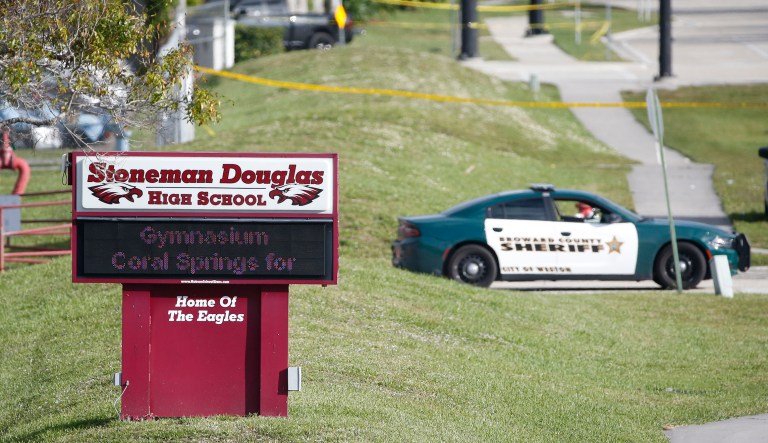 Law enforcement officers block off the entrance to Marjory Stoneman Douglas High School.