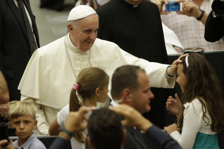 Pope Francis blesses a child during the weekly general audience in the Paul VI hall, at the Vatican, Wednesday, Aug. 6, 2014. (AP Photo/Andrew Medichini)