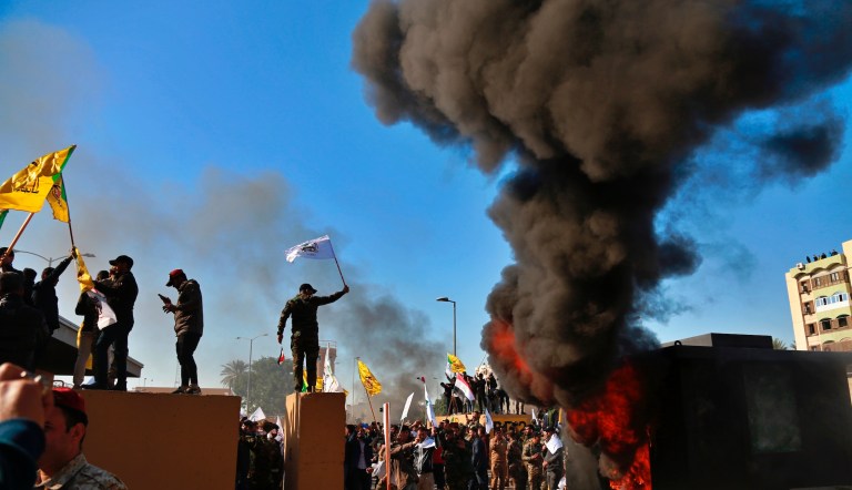 Protesters burn property in front of the U.S. embassy compound, in Baghdad, Iraq, Tuesday, Dec. 31, 2019. Dozens of angry Iraqi Shiite militia supporters broke into the U.S. Embassy compound in Baghdad on Tuesday after smashing a main door and setting fire to a reception area, prompting tear gas and sounds of gunfire.