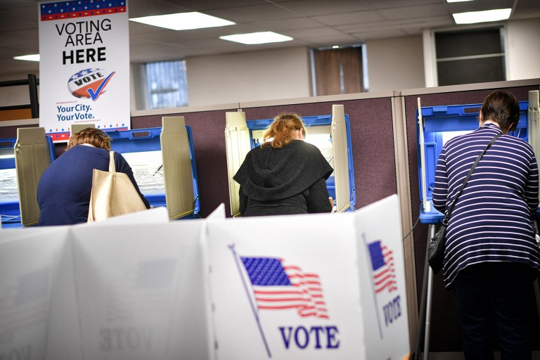 Voters cast their ballots at a voting center. Early votes or absentee ballots have been returned by at least 455,878 people. (Glen Stubbe/Star Tribune via AP)