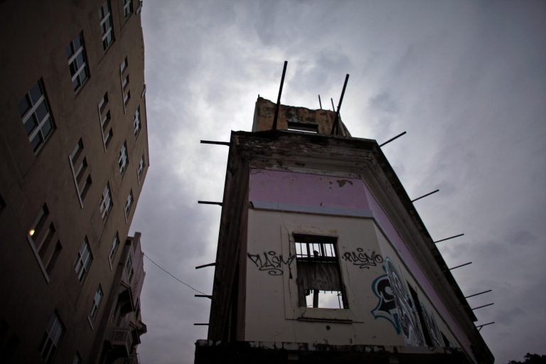 An abandoned building sits under cloudy skies during a rainy day in Old San Juan, Puerto Rico, Tuesday, Nov. 4, 2014. (AP Photo/Ricardo Arduengo)
