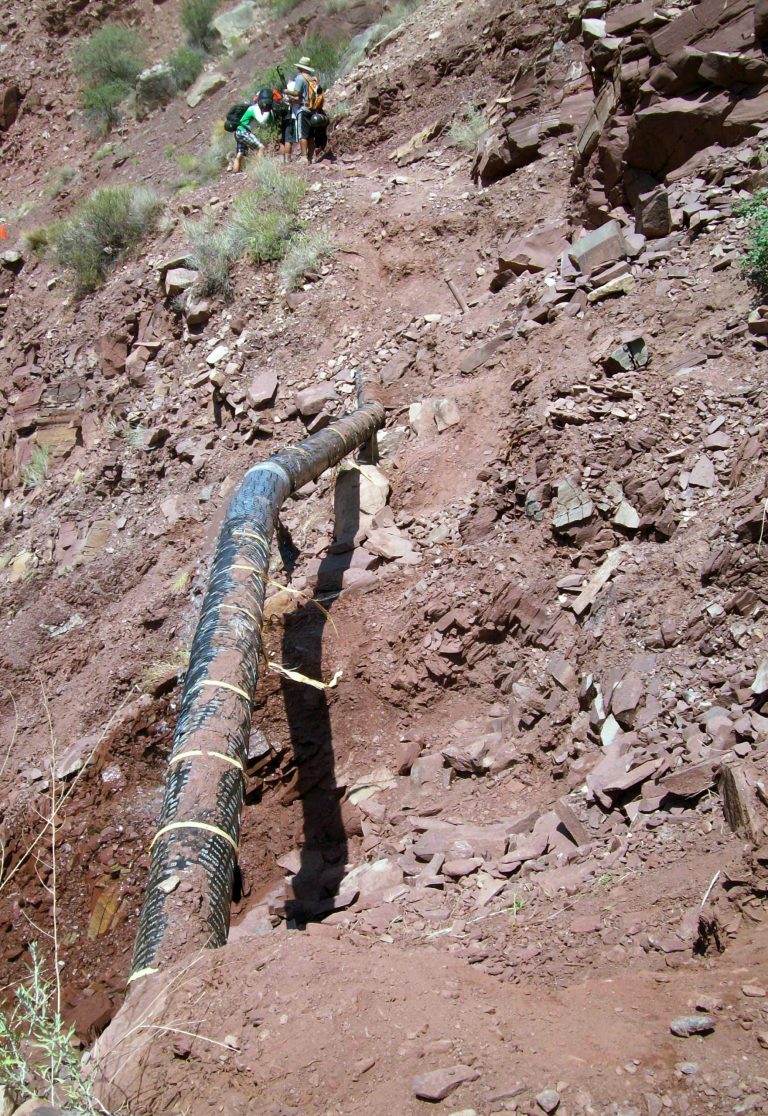 This undated photo shows hikers walking near a water pipeline that runs through Grand Canyon National Park, Arizona. Two pipelines that feed water from a spring deep in the canyon to storage tanks on the rim are the top priority for maintenance in the national park, and replacing them could cost up to $200 million. (AP Photo/Grand Canyon National Park)