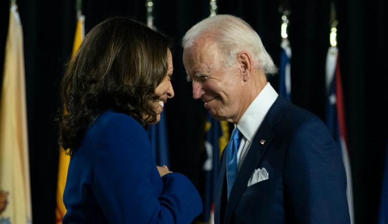 Democratic presidential candidate former Vice President Joe Biden and his running mate Sen. Kamala Harris, D-Calif., pass each other as Harris moves to the podium. To speak during a campaign event at Alexis Dupont High School in Wilmington, Del., Wednesday, Aug. 12, 2020.                                                                   