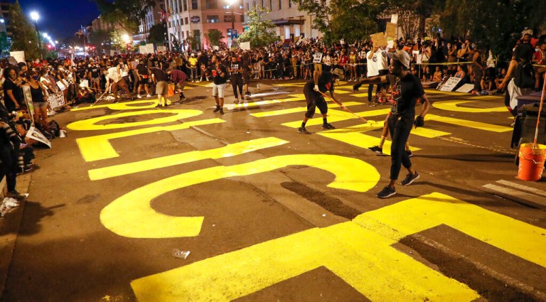 Demonstrators paint the words 'defund the police' near the White House.