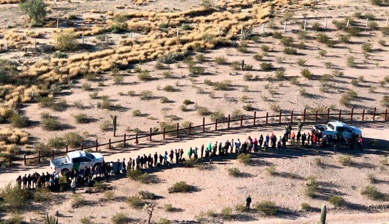 In this Thursday, Feb. 7, 2019, aerial image released by the U.S. Customs and Border Protection, migrants, apprehended after illegally crossing along the U.S.-Mexico border near Lukeville, Ariz., are lined up. A group of 325 Central Americans surrendered to agents on Thursday after entering the United States illegally.