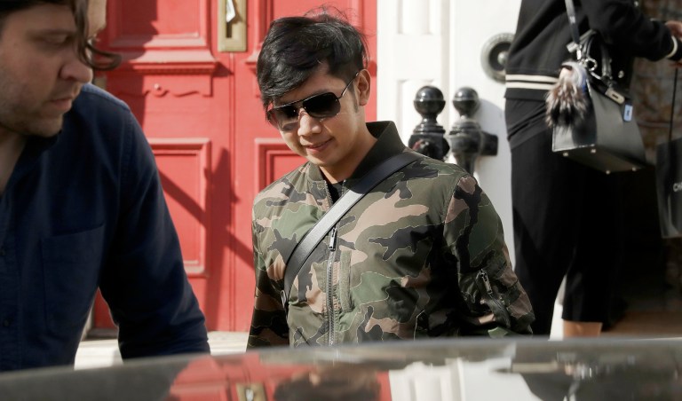 FILE - In this April 5, 2017, file photo, Vorayuth "Boss" Yoovidhya, whose grandfather co-founded energy drink company Red Bull, walks to get in a car as he leaves a house in London. With the clock about to run out on a hit-and-run charge, the whereabouts of an heir to the Red Bull energy-drink empire accused of killing a Bangkok police officer five years ago are unknown. The fugitive, whose family is worth billions, has apparently found a way to disappear. 