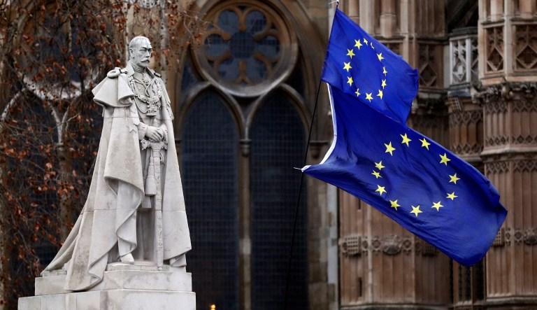 The EU flags wave next to the statue of King George V in Westminster, London, Wednesday, Jan. 16, 2019. British lawmakers overwhelmingly rejected Prime Minister Theresa May's divorce deal with the European Union on Tuesday, plunging the Brexit process into chaos and triggering a no-confidence vote that could topple her government.