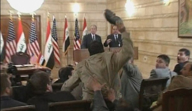 In this image from APTN video, a man, centre throws a shoe at US President George W. Bush, background left, during a news conference with Iraq Prime Minister Nouri al-Maliki, Sunday, Dec. 14, 2008, in Baghdad, Iraq.