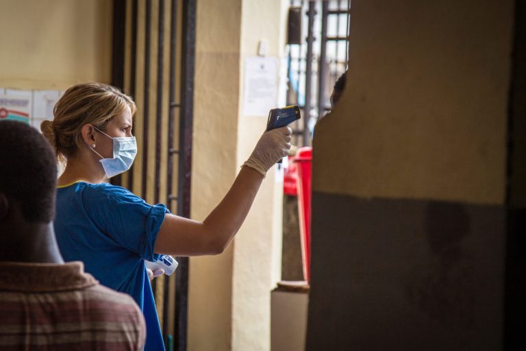 In this photo taken on Friday, Aug. 29, 2014, a health worker measures a patient's temperature at the Connaught Hospital, which has suffered the loss of medical workers in the past from the Ebola virus, in Freetown, Sierra Leone.  Dr. Sheik Humarr Khan was one of those on the front lines of the Ebola outbreak. The tireless Khan was jovial but forceful, doling out praise and criticism to junior doctors at his hospital. But Khan became infected and died, and so have at least 120 other medical workers in Sierra Leone and in three other countries, creating immediate and long-term impacts in a region that already had an understaffed and under equipped health care system. (AP Photo/ Michael Duff)