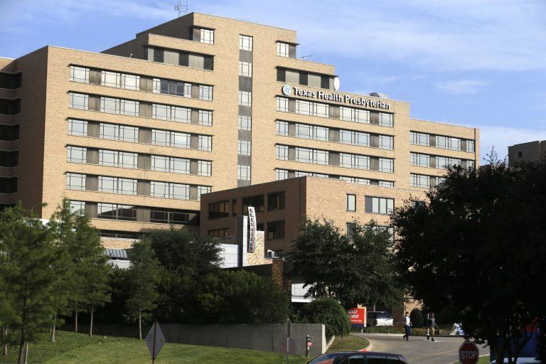 Pedestrians walk outside Texas Health Presbyterian Hospital in Dallas. (AP Photo/LM Otero)