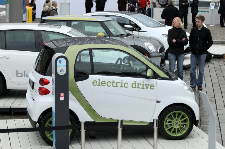 Visitors look at an outdoor presentation of electric cars by auto manufacturers Smart, Volkswagen, Mini and Opel as part of the German government's 'National Electromobility Development Plan' on May 3, 2010 in Berlin, Germany. (Photo by Sean Gallup/Getty images)