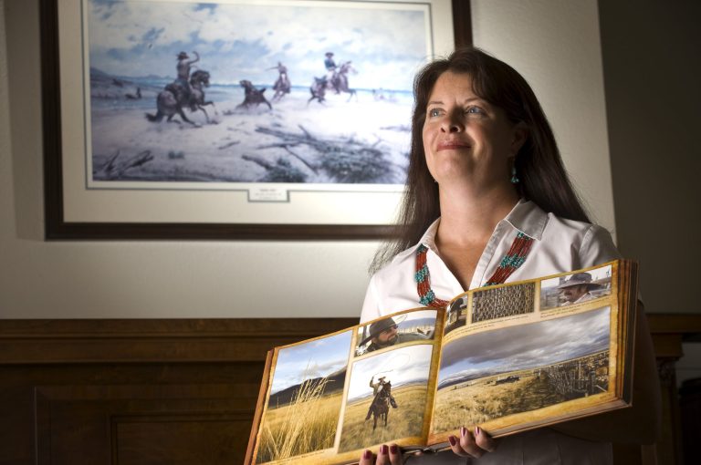 Ramona Morrison, daughter of Wayne Hage, holds a book by Jim Keen open to a spread on her father's ranch, currently run by her brother, in her Sparks home Wednesday, July 17, 2008. (AP Photo/Scott Sady)