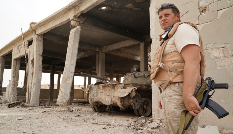 A Russian military officer stands in front of a destroyed bomb factory operated by Islamic State militants in the town of Okeirbat, northern Hama province, Syria, Friday, Sept. 15, 2017. A statement from U.S. Central Command said ISIS forces 