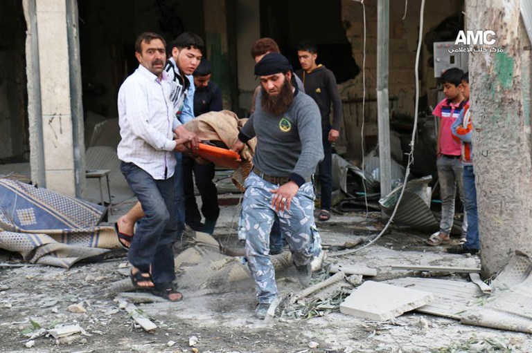 This photo provided by the anti-government activist group Aleppo Media Center (AMC), an anti-Bashar Assad activist group, which has been authenticated based on its contents and other AP reporting, shows Syrian men carrying a covered dead body after a government airstrike attack in the al-Mayssar neighborhood, in Aleppo, Syria, Thursday April 3, 2014. Mortar fire killed several people in a suburb of the Syrian capital Thursday, activists and state media said, amid reports that clashes in a coastal province killed a top foreign fighter who was a former Guantanamo Bay detainee. (AP Photo/Aleppo Media Center, AMC)