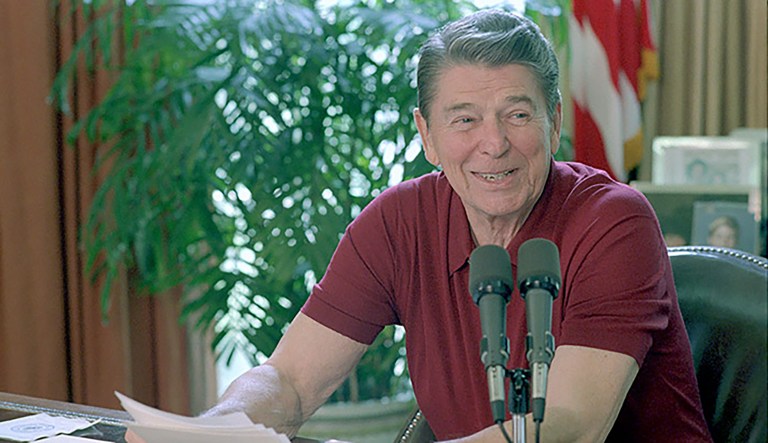 President Ronald Reagan sitting at his desk in the Oval Office, giving a radio address to the nation on international trade on July 11, 1987.