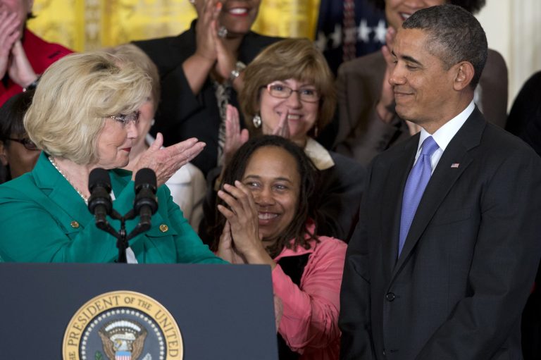 Womenâs rights activist Lilly Ledbetter, left, acknowledges President Obama as she speaks in the East Room of the White House in Washington, Tuesday, April 8, 2014, during an event marking Equal Pay Day. (AP Photo/Carolyn Kaster)