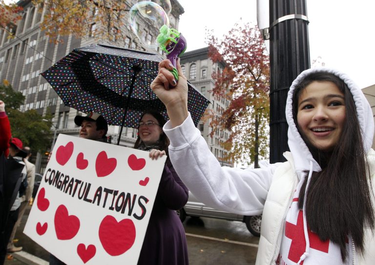   Aya Bentley, right, 14, of Bellevue, Wash., uses a small bubble-maker as she joins other well-wishers congratulating gay and lesbian newlyweds at Seattle City Hall Sunday, Dec. 9, 2012, in Seattle. Gov. Chris Gregoire signed a voter-approved law legalizing gay marriage Wednesday, Dec. 5 and weddings for gay and lesbian couples began in Washington state on Sunday, following the three-day waiting period after marriage licenses were issued earlier in the week. (AP Photo/Elaine Thompson)  