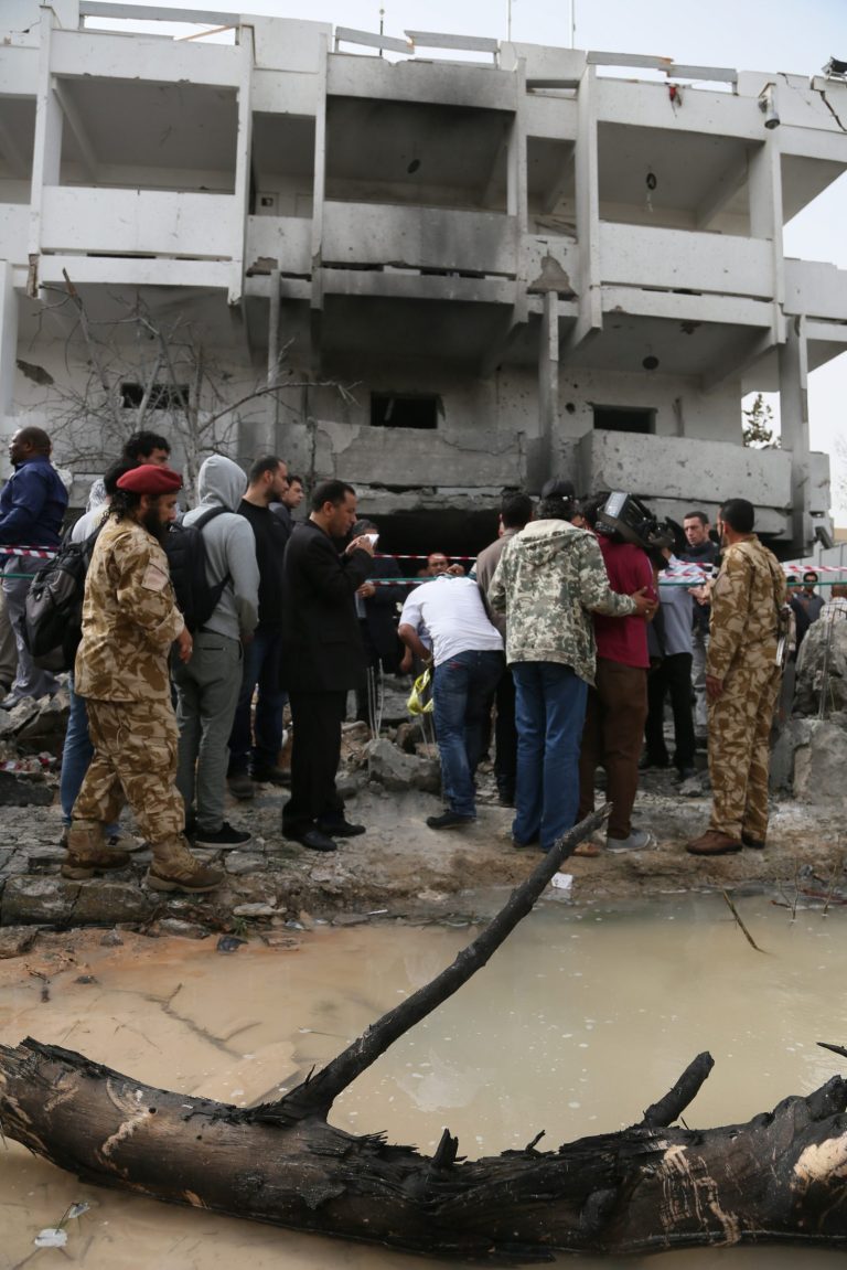 Security personnel and journalists inspect the site of a car bomb that targeted the French embassy wounding two French guards and causing extensive material damage in Tripoli, Libya, Tuesday, April 23, 2013. The explosives-laden car was detonated just outside the embassy building in Tripoli's upscale al-Andalus neighborhood, officials said. (AP Photo/Abdul Majeed Forjani)