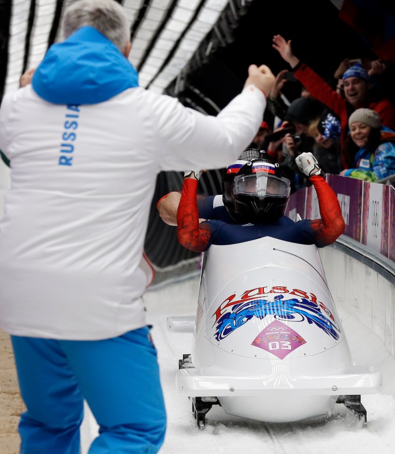 The team from Russia RUS-1, piloted by Alexander Zubkov and brakeman Alexey Voevoda, celebrate with a coach after their final run during the men's two-man bobsled competition at the 2014 Winter Olympics, Monday, Feb. 17, 2014, in Krasnaya Polyana, Russia. The Russian team won the gold medal. (AP Photo/David J. Phillip )