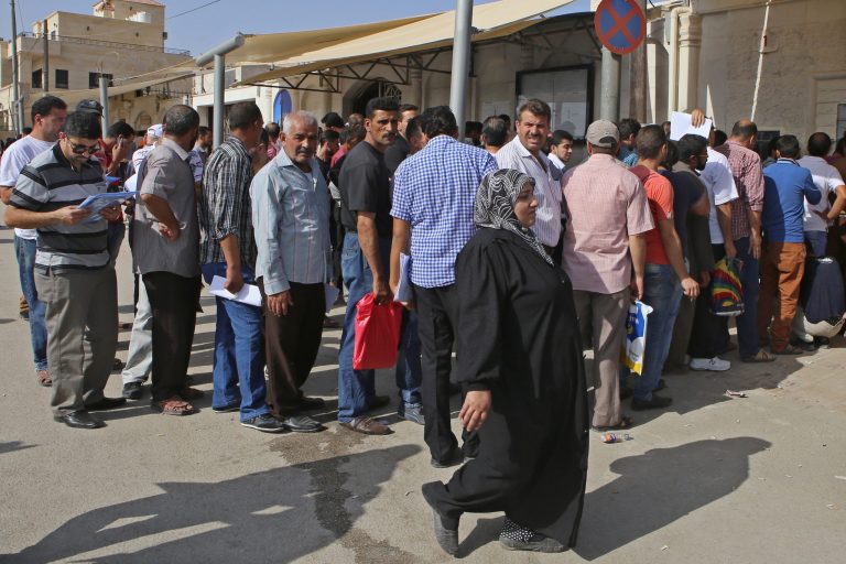 In this Tuesday, Sept. 15, 2015 photo, Hundreds of Syrian refugees line up at their country's embassy in the hopes for a better future in Europe. (AP Photo/Raad Adayleh)