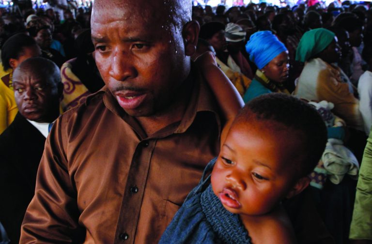 Mourners attend a memorial service at the Lonmin Platinum Mine near Rustenburg, South Africa, Thursday, Aug. 23, 2012 for striking miners that were shot and killed by police last week. (AP Photo/Denis Farrell)