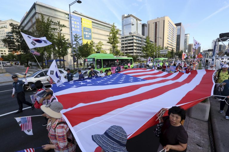Supporters of former South Korean President Park Geun-hye march with a U.S. flag during a rally urging the deployment of an advanced U.S. missile defense system called Terminal High-Altitude Area Defense, or THAAD, in Seoul, South Korea, Saturday, Aug. 12, 2017. Chinese President Xi Jinping made a plea for cool-headedness over escalating tensions between the U.S. and North Korea in a phone conversation with U.S. President Donald Trump on Saturday, urging both sides to avoid words or actions that could worsen the situation.(AP Photo/Ahn Young-Joon)
