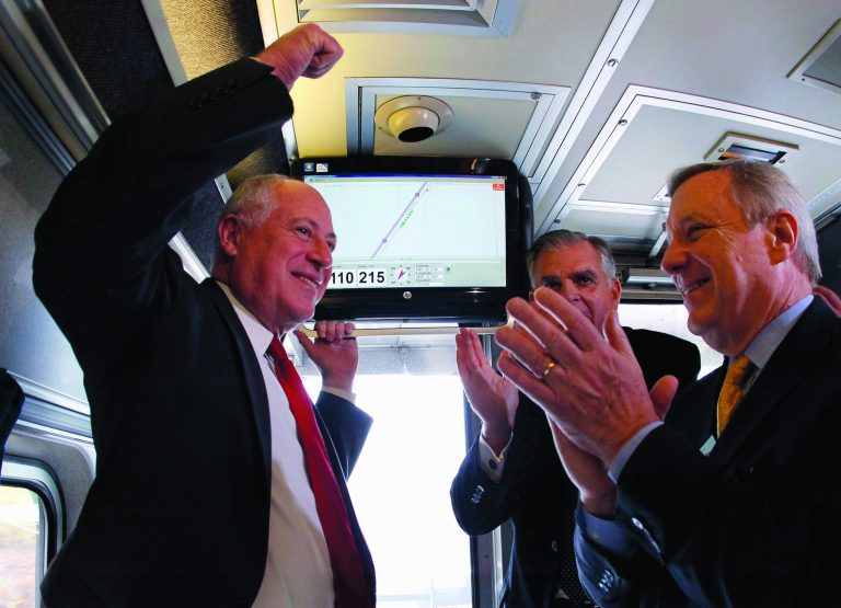 FILE - In this Oct. 19, 2012 file photo, Gov. Pat Quinn, left, U.S. Transportation Sec. Ray LaHood, center, and Sen. Dick Durbin, D-Ill., celebrate in Pontiac, Ill., after the Amtrak train they are riding reached 110 mph during a test run between Pontiac and Dwight, Ill. Hundreds of Midwest manufacturers stand to benefit from a web of high-speed passenger rail routes emerging from Chicago's rail hub, according to a report released by an environmental policy group that has fought to defend the use of billions in taxpayer money on such projects. (AP Photo/Charles Rex Arbogast, File)