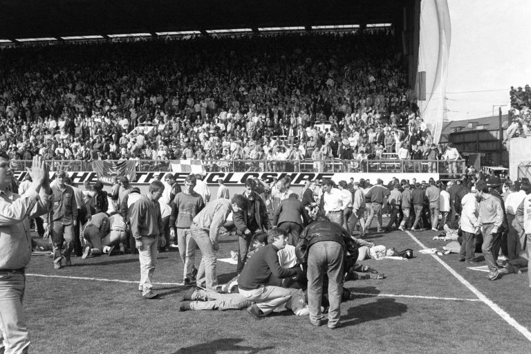  FILE - This is an April 15, 1989 file photo of fans on the pitch receiving attention after severe crushing at Hillsborough stadium in Sheffield England during an FA Cup semi-final football match between Liverpool and Nottingham Forest. A London court Wednesday Dec. 19, 2012 has overturned a previous ruling that the death of 96 Liverpool fans in the 1989 Hillsborough disaster was accidental, and a new criminal investigation into the stadium tragedy was ordered. The wrongdoing and mistakes that led to the crush at an FA Cup semifinal against Nottingham Forest were only fully exposed in September after an independent panel examined previously secret documents, vindicating a 23-year search for the truth by the victims' families. (AP Photo/PA, File) UNITED KINGDOM OUT   